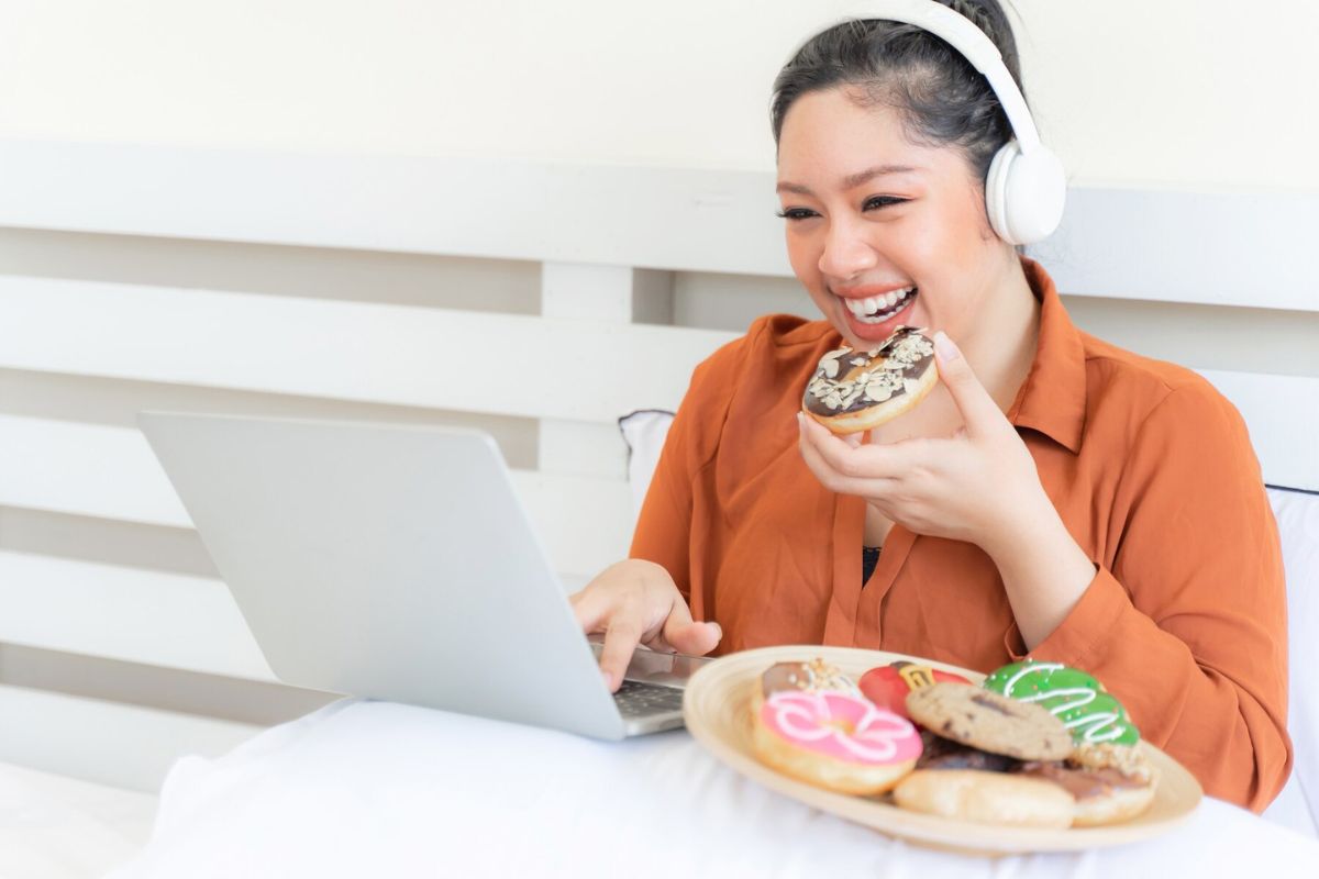 Seorang wanita sedang memakan donat