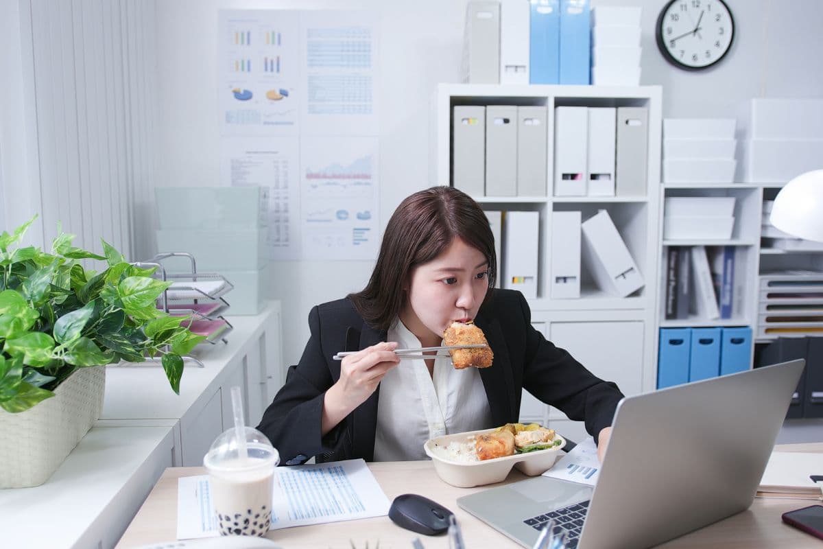 Seorang wanita sedang makan siang di kantor