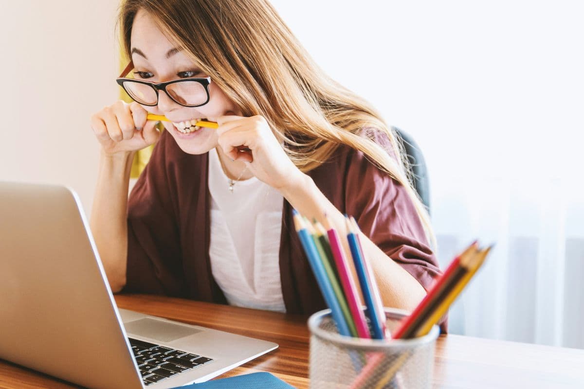 orang yang sedang menggigit pensil karena stress