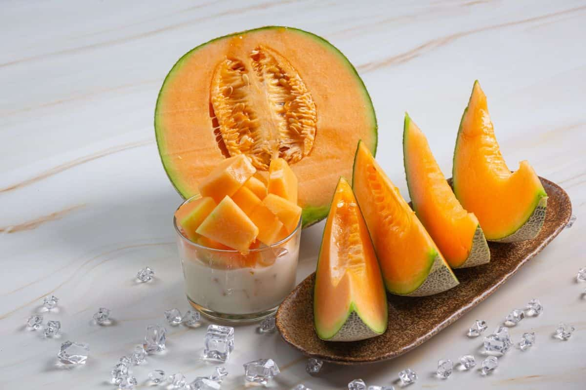 Potongan melon di atas piring dan di dalam gelas