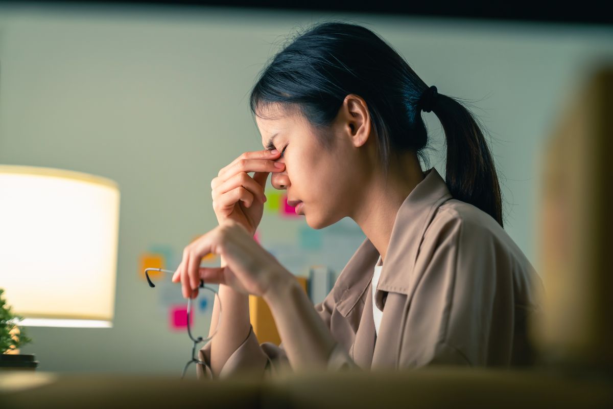 Seorang wanita yang sedang stress karena pekerjaan