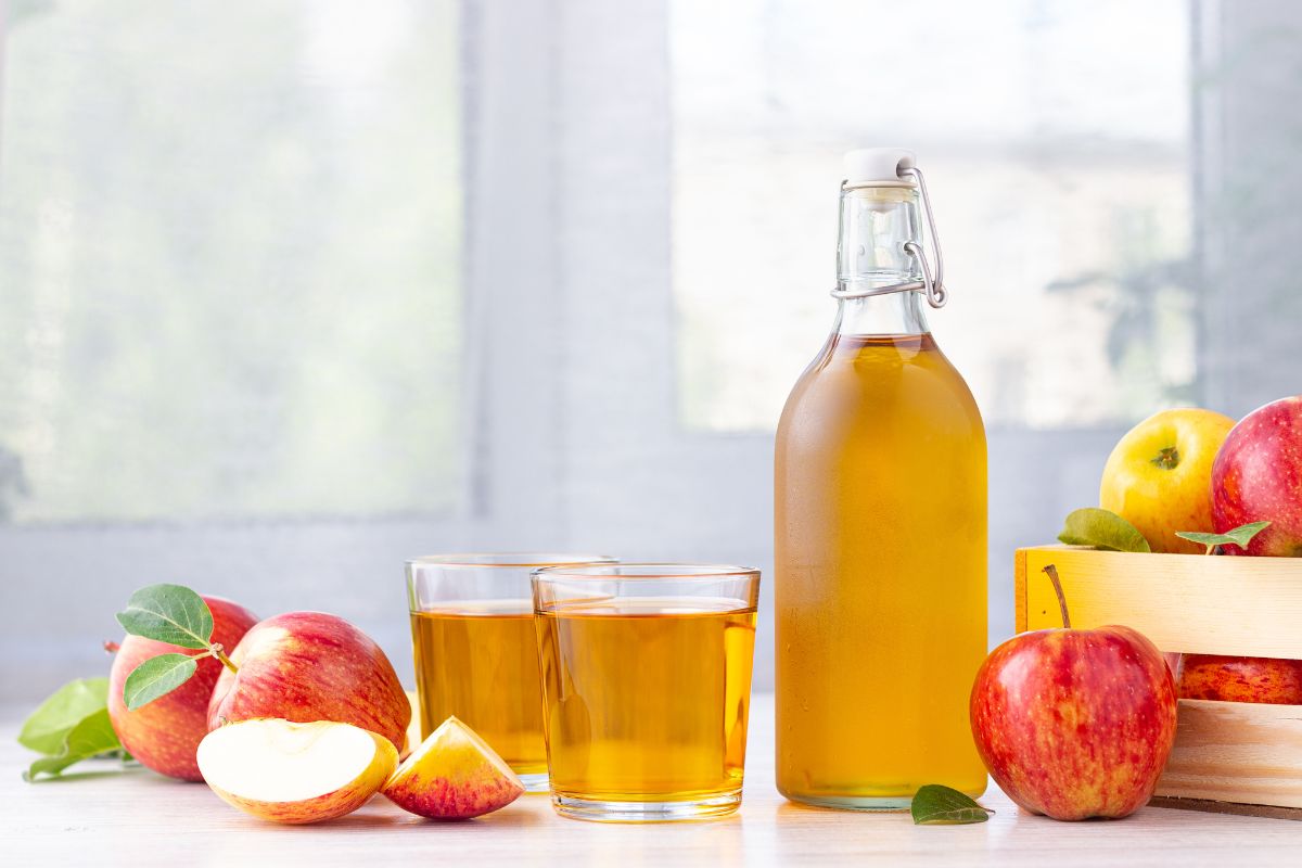 Satu botol dan dua gelas Apple Cider Vinegar