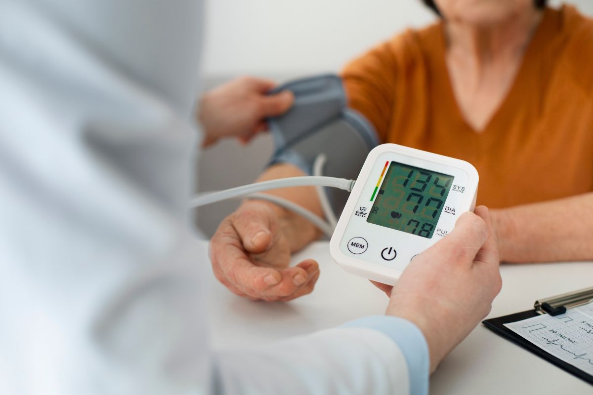 dokter yang mengecek tekanan darah pasien