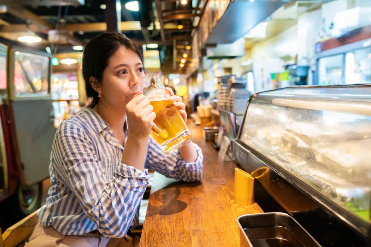 Seorang wanita sedang minum minuman beralkohol di bar