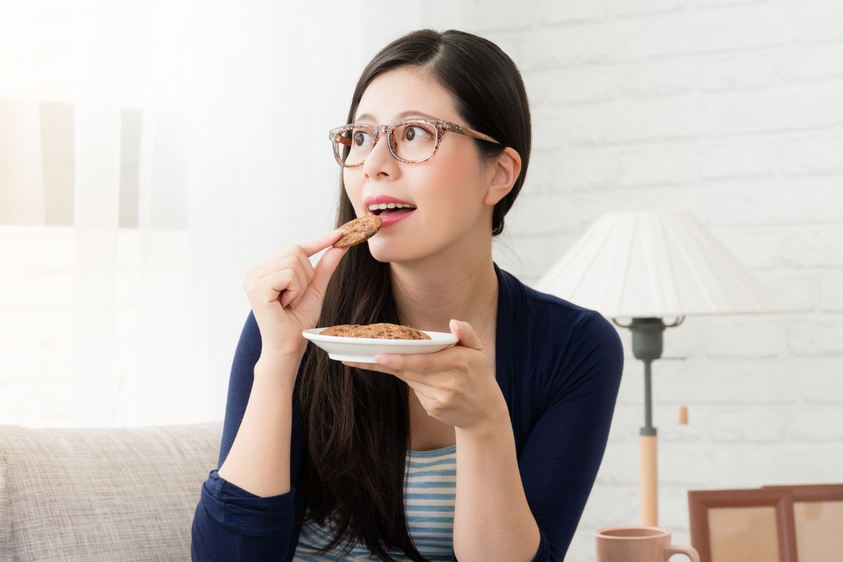 Wanita sedang memakan camilan