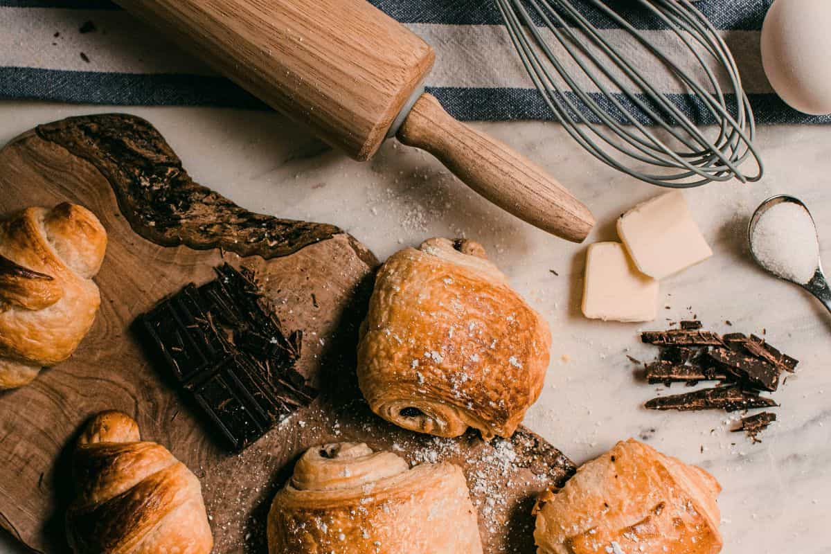 beberapa croissant dan pain au chocolat di dekat alat baking