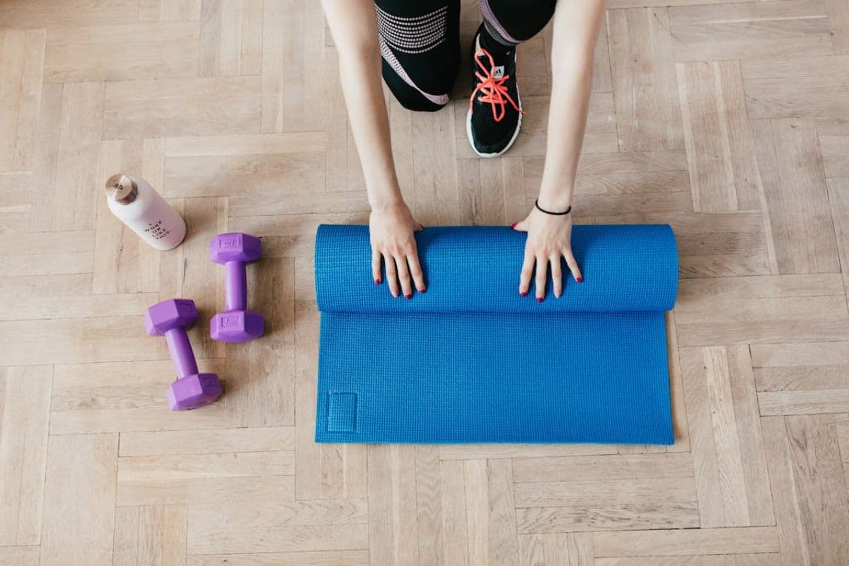 Perempuan menggulung yoga mat