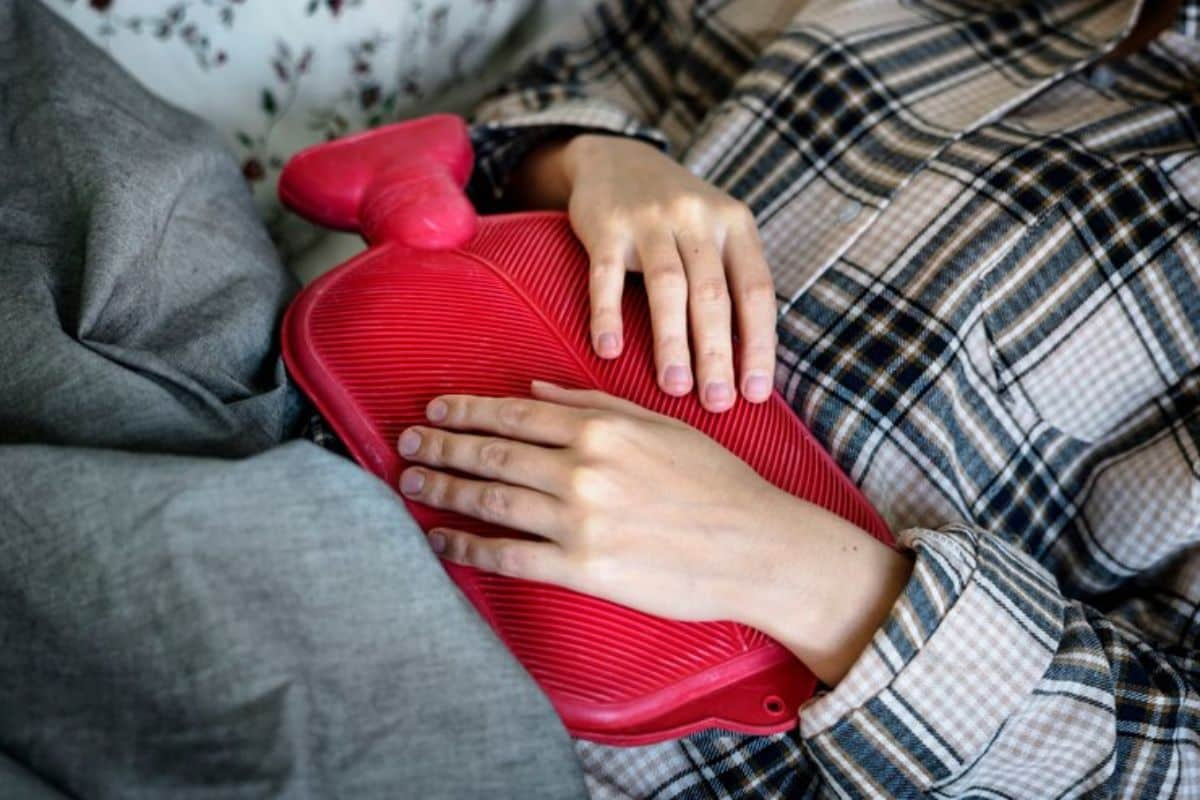 seorang wanita meletakkan heating pads di perut