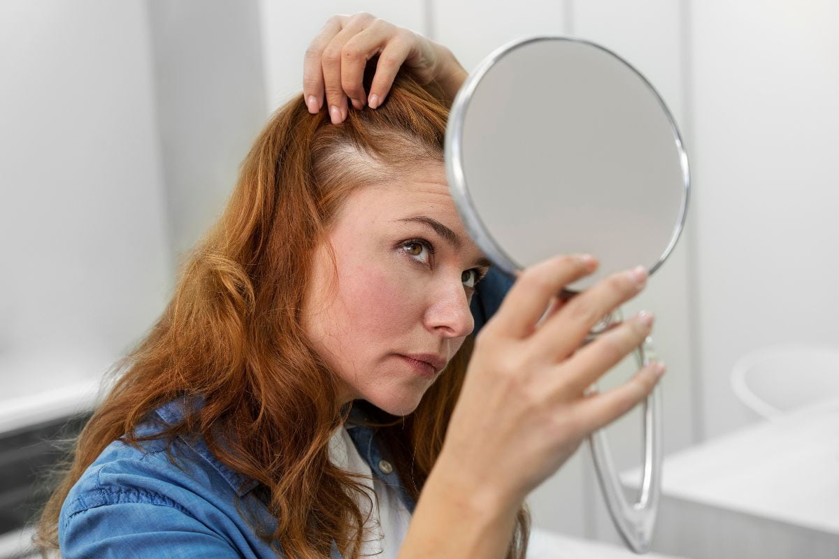 orang yang sedang melihat kondisi kulit kepala di cermin