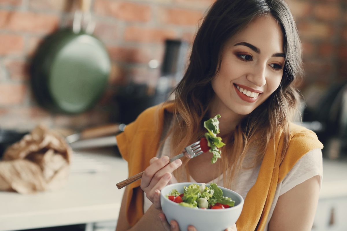 orang yang sedang memakan salad di mangkok