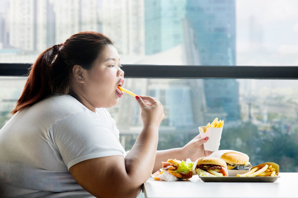 Wanita obesitas sedang menyantap makanan