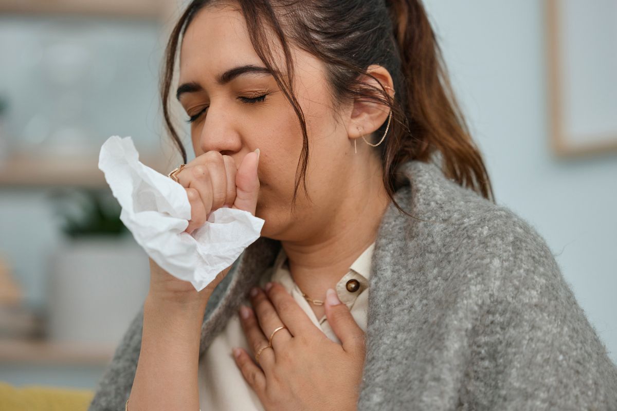 Seorang wanita sedang batuk dan flu