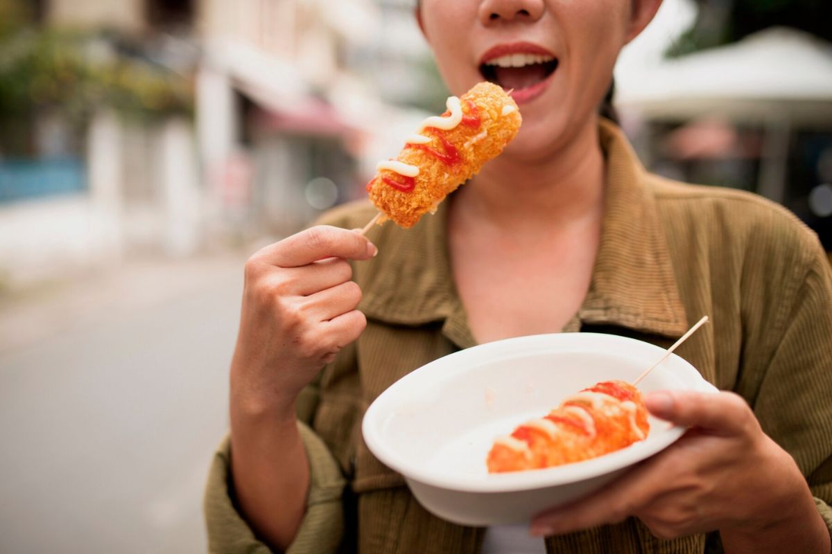 Wanita memakan corndog