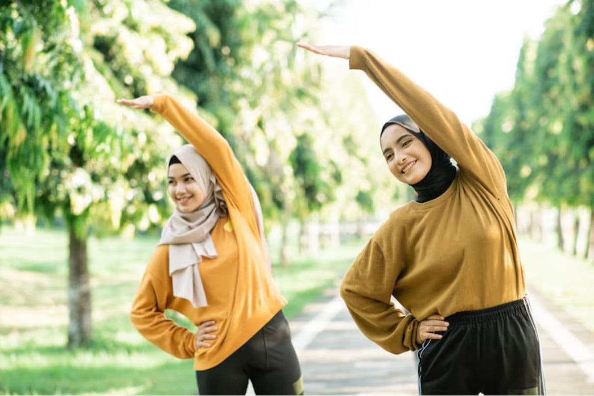 Dua gadis berjilbab sedang olahraga di taman