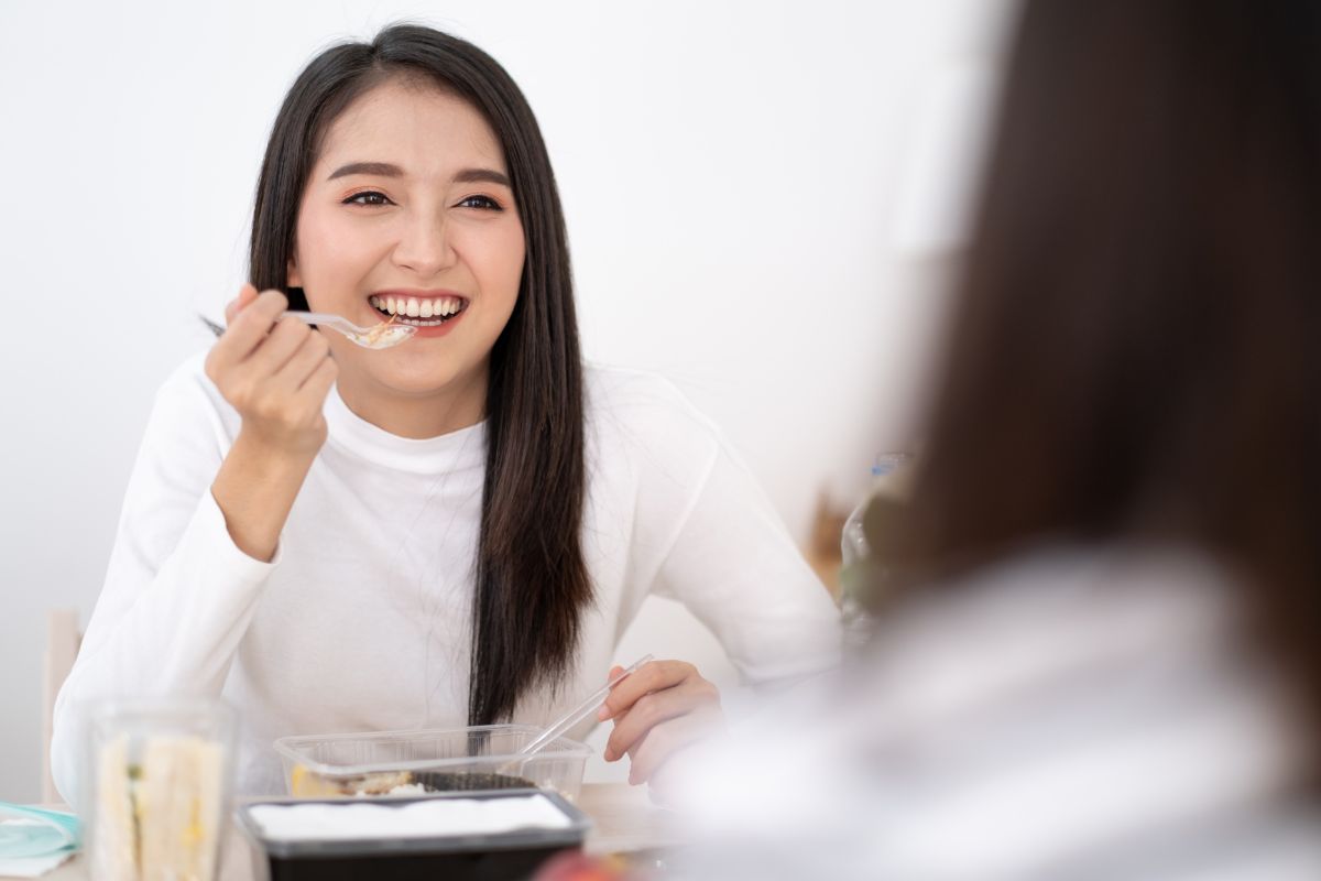 Seorang wanita sedang menikmati makanan