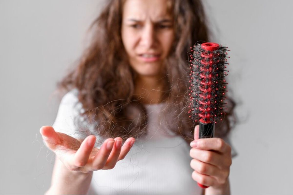 seorang wanita dengan sisir dan rambut rontok